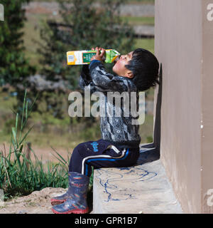 Chinchero Perù : 18 maggio : Giovane ragazzo andina di bere al di fuori di un grande cartone di succo di frutta. Il 18 maggio 2016, Chinchero Perù. Foto Stock