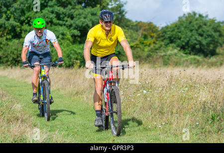 I ciclisti che indossa caschi nella campagna della South Downs nel West Sussex, in Inghilterra, Regno Unito. Uno stile di vita sano. Foto Stock