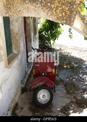 Vecchia Vespa scooter moto sotto arch al di fuori del vecchio borgo casa di xantati Corfu Grecia Foto Stock