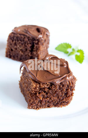 Mini cioccolato torte con glassa di cioccolato e menta sulla piastra bianca close up Foto Stock