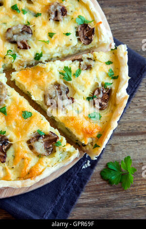 In casa francese torta quiche con funghi champignon () e formaggio oltre rustico sfondo di legno Foto Stock