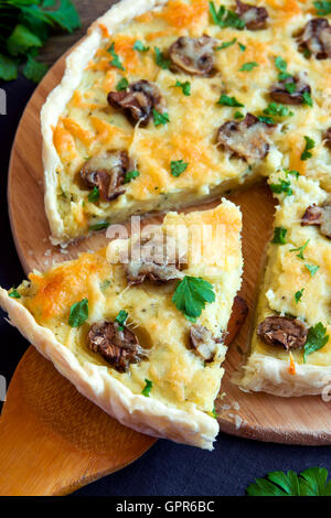 In casa francese torta quiche con funghi champignon () e formaggio oltre rustico sfondo di legno Foto Stock