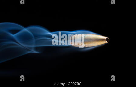 Uno color rame bullet e fumo dietro su sfondo nero Foto Stock