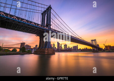 La città di New York a Manhattan Bridge spanning l'East River durante il tramonto. Foto Stock