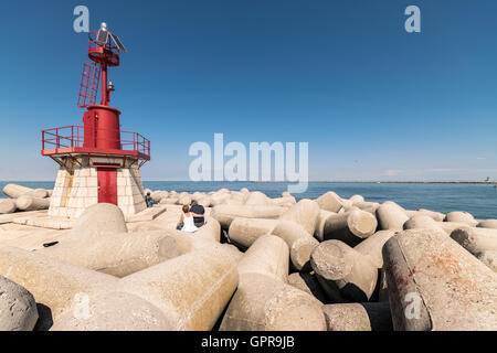 Faro rosso che indica l'entrata del porto. Foto Stock