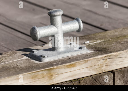 Piccolo grigio mooring bollard montato sul molo in legno, attrezzature portuali Foto Stock