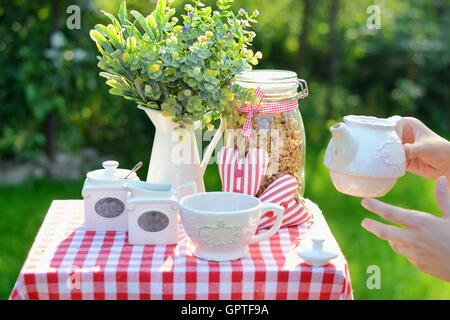 Tazza di gustoso tè serviti nel giardino estivo Foto Stock