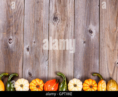 Vista aerea stagionale di autunno gourd decorazioni, bordo inferiore, su rustiche tavole di legno. Foto Stock