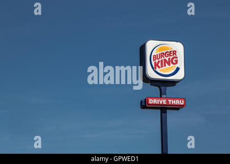 Un segno per un Burger King guidare attraverso il magazzino elevato su un palo alto. Foto Stock