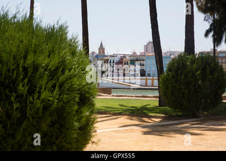 Il Guadalquivir nel centro di Sevilel Spagna con tourist river cruise vantano adn ciclisti sulle rive del fiume. Foto Stock