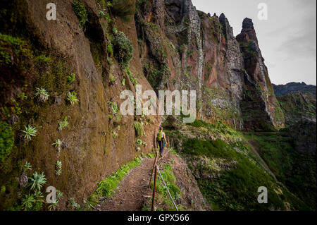 Donna escursionista sta andando sul bordo della ripida montagna Foto Stock