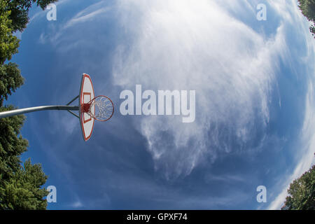 Un suburban Basketball hoop contro il cielo blu. Foto Stock