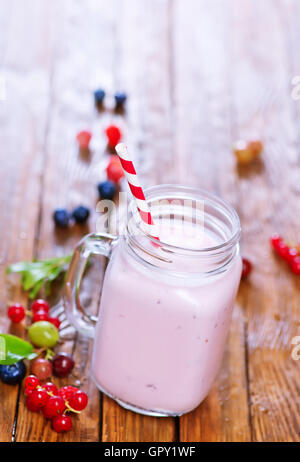 Yogurt con frutti di bosco in vetro e su un tavolo Foto Stock