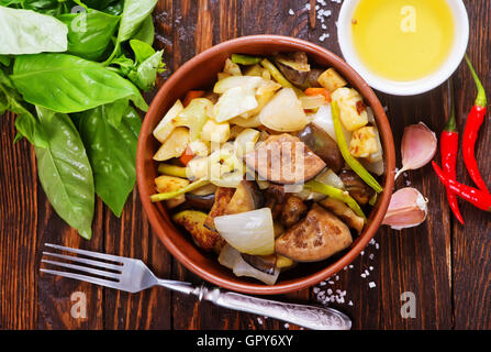 Verdure fritte in un recipiente e su un tavolo Foto Stock