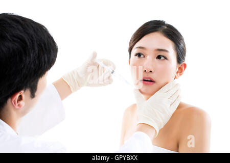 Chirurgia plastica/ giovane donna asiatica che riceve un iniezione di Botox da un medico Foto Stock