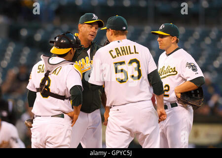 Giugno 14, 2011; Oakland, CA, Stati Uniti d'America; Oakland Athletics pitching coach Ron Romanick (retro) parla di iniziare il pitcher Trevor Cahill (53) sull'brocche tumuli durante la quinta inning contro Kansas City Royals a Oakland-Alameda County Coliseum. Foto Stock