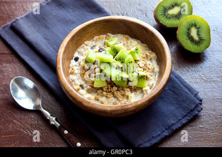 Muesli fatti in casa con latte e kiwi per una sana prima colazione Foto Stock