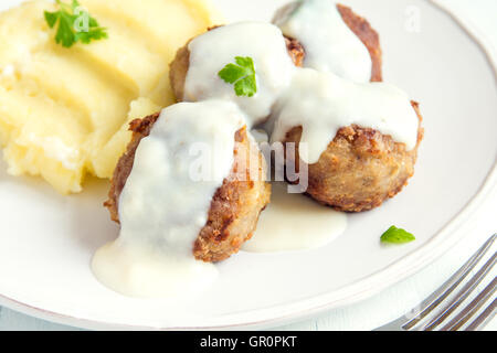 Le polpette di carne bianca con salsa cremosa e mash su piastra close up Foto Stock