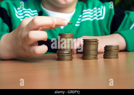 Impilatura di mano il conteggio delle monete in euro (denaro) sul tavolo di legno Foto Stock