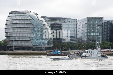 Il Maritime autonomia banco di prova di superficie (montante), una superficie senza equipaggio nave (centro) e la sua escort HMS Archer (destra) pass City Hall come il montante è testato sul fiume Thames, London, come parte dei preparativi per la Royal Navy di "Unmanned Warrior" programma di prova questo autunno. Foto Stock