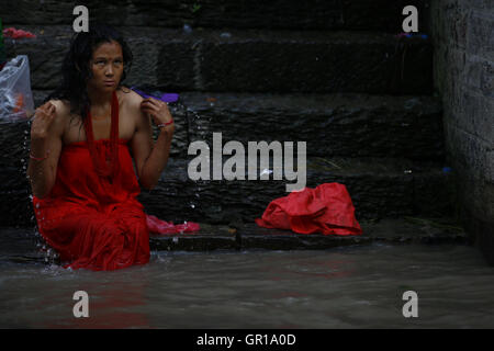 Kathmandu, Nepal. 6 Sep, 2016. Un Nepalese donna Indù lavaggi se stessa per la purificazione nel fiume Bagmati all'interno del tempio Pashupathinath premessa, un sito Patrimonio Mondiale dell'UNESCO a Kathmandu, Nepal martedì 6 settembre, 16. Rishi panchami è osservata per contrassegnare la fine di tre giorni di festival Teej quando le donne culto Sapta Rishi (Sette Santi) l'ultimo giorno per lavare via le impurità per tutto l'anno. Credito: Skanda Gautam/ZUMA filo/Alamy Live News Foto Stock