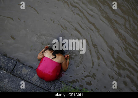 Kathmandu, Nepal. 6 Sep, 2016. Un Nepalese donna Indù lavaggi se stessa per la purificazione nel fiume Bagmati all'interno del tempio Pashupathinath premessa, un sito Patrimonio Mondiale dell'UNESCO a Kathmandu, Nepal martedì 6 settembre, 16. Rishi panchami è osservata per contrassegnare la fine di tre giorni di festival Teej quando le donne culto Sapta Rishi (Sette Santi) l'ultimo giorno per lavare via le impurità per tutto l'anno. Credito: Skanda Gautam/ZUMA filo/Alamy Live News Foto Stock