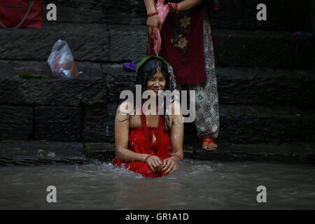 Kathmandu, Nepal. 6 Sep, 2016. Un Nepalese donna Indù offerto acqua santa per la purificazione sulle rive del fiume Bagmati all'interno del tempio Pashupathinath premessa, un sito Patrimonio Mondiale dell'UNESCO a Kathmandu, Nepal martedì 6 settembre, 16. Rishi panchami è osservata per contrassegnare la fine di tre giorni di festival Teej quando le donne culto Sapta Rishi (Sette Santi) l'ultimo giorno per lavare via le impurità per tutto l'anno. Credito: Skanda Gautam/ZUMA filo/Alamy Live News Foto Stock