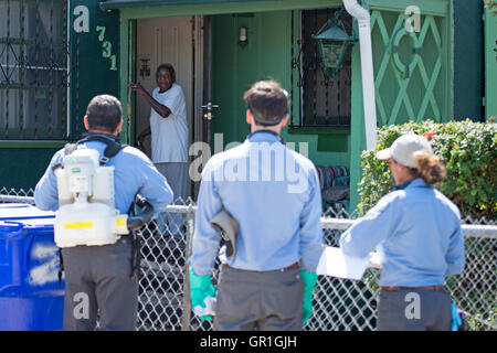 San Diego, California, Stati Uniti d'America 06 Settembre 2016 - della Contea di San Diego vettore tecnici di controllo parla con un residente locale prima di spruzzare la sua proprietà nel Mt. Speranza quartiere di San Diego. La spruzzatura è il risultato di un viaggio-relative Zika caso nella zona. Credito: Craig Steven Thrasher/Alamy Live News Foto Stock