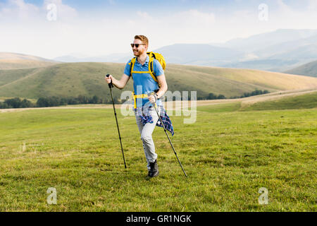 Giovane uomo gode di escursionismo in una giornata di sole Foto Stock