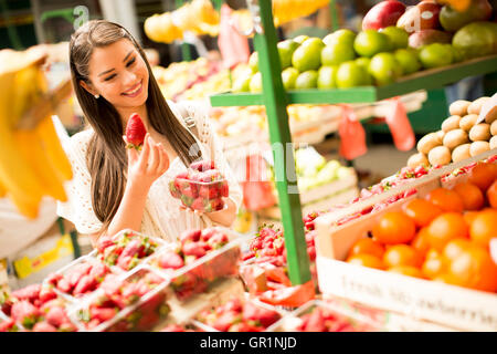 Giovane donna alla ricerca e acquisto di frutta fresca al mercato Foto Stock