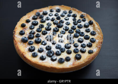 In casa torta bluebrry su una superficie di legno. Fresca pasta cotta su una piastra. Close up macro, squisita crostata cremosa Foto Stock