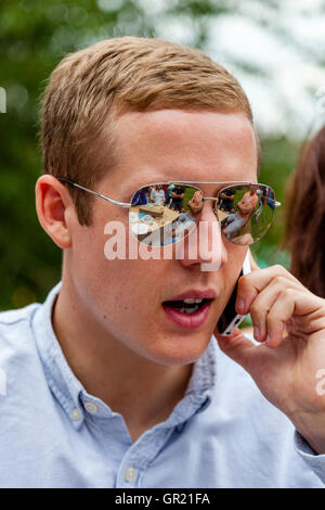 Una buona ricerca giovane uomo utilizzando un telefono cellulare, Sussex, Regno Unito Foto Stock