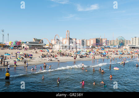 Coney Island Beach con il Boardwalk e Luna Park giostre in background. New York. Foto Stock