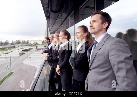 Team Aziende in piedi sul balcone di edificio per uffici Foto Stock