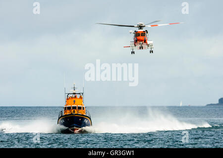 Sikorsky S-92 dalla guardia costiera irlandese accompagna Portrush scialuppa di salvataggio, RNLB William Gordon bava Foto Stock