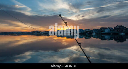 Una canna da pesca si profila all'alba nel porto di pietra, New Jersey Stati Uniti | gite in barca al tramonto sulla baia | pesca in mare profondo Foto Stock