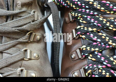 Makeover tema e concetto. Old Dirty boot vs lucidato e realizzato al di sopra di boot con la nuova coloratissima lacci. Close up di laces tema. Foto Stock