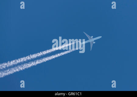 Air Canada Boeing 777 aereo di linea volando ad altitudine di crociera con un lungo white contrail trailing dell'aeromobile. Foto Stock