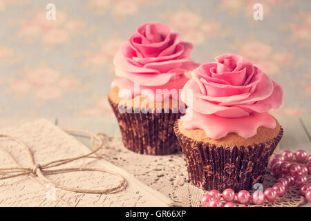 Tortine con dolci rose fiori e una lettera Foto Stock