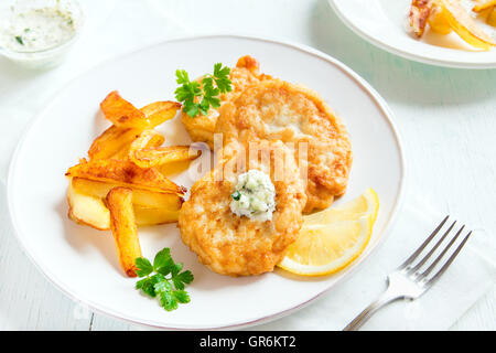 Fatti in casa Torte di pesce con patatine fritte sulla piastra bianca close up Foto Stock