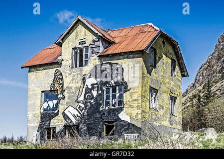 Un ritratto di grandi dimensioni adorna la parete di questa casa di fuoco rovine sulla Lonely Lofoten Gimsøy Foto Stock