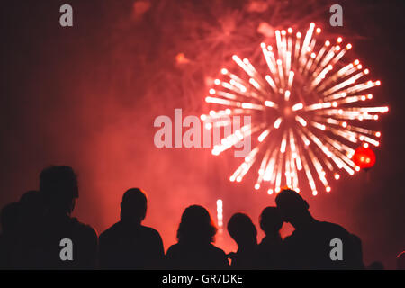 Felici le persone a guardare i fuochi d'artificio Foto Stock