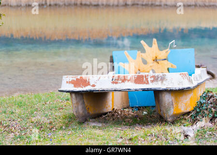 Barche a pedali e abbandonato sulla riva del lago Foto Stock