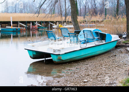 Barche a pedali e abbandonato sulla riva del lago Foto Stock