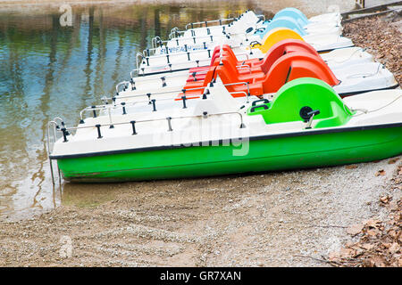 Barche a pedali e abbandonato sulla riva del lago Foto Stock