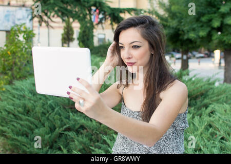 Giovane donna prendendo selfie con un dispositivo tablet pc Foto Stock