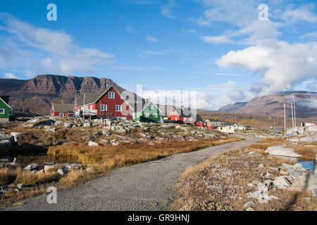 Case in legno, con le montagne alle spalle, Qeqertarsuaq, Groenlandia Foto Stock