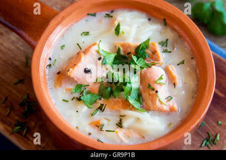 Zuppa di salmone con pasta e verdure in vaso di ceramica close up Foto Stock