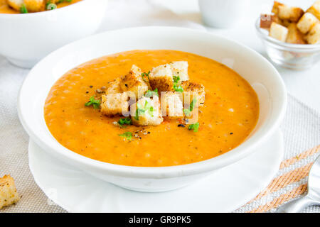 Verdure zuppa di pomodoro e carote con crostini, verdi e spezie in ciotola bianco Foto Stock