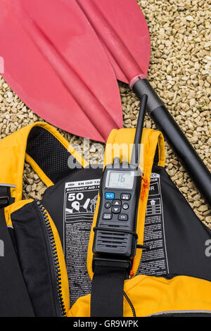 Kayak paddle, aiuti di galleggiamento e una radio VHF. Foto Stock